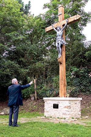 Le Père François Cléret, bénissant la croix le 27 juin dernier.