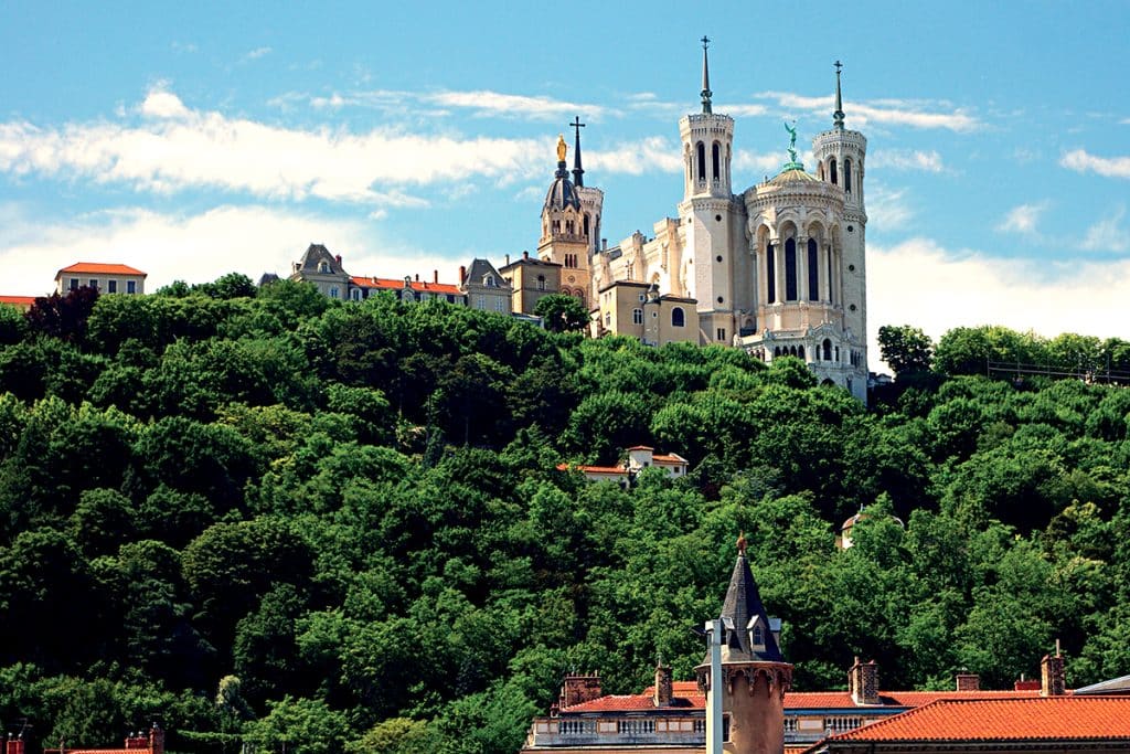 Colline de Fourvière à Lyon et sa basilique, ainsi que la maison de Lorette de Pauline Jaricot, dans les arbres en contrebas.