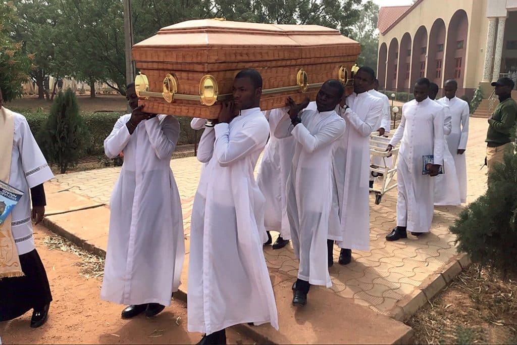Séminaristes portant le cercueil du Père Borogo lors de ses funérailles, le 30 juin 2022.