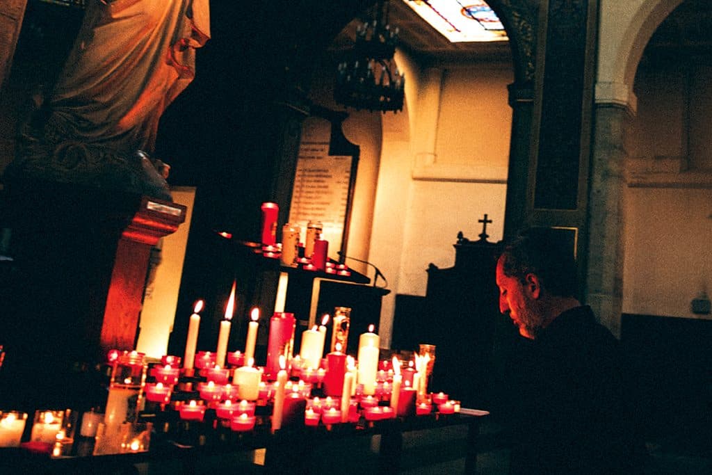 Gad Elmaleh se recueillant devant une statue de la Vierge, lors d’une scène tournée dans l’église de Notre-Dame-de-Grâce de Passy (Paris).